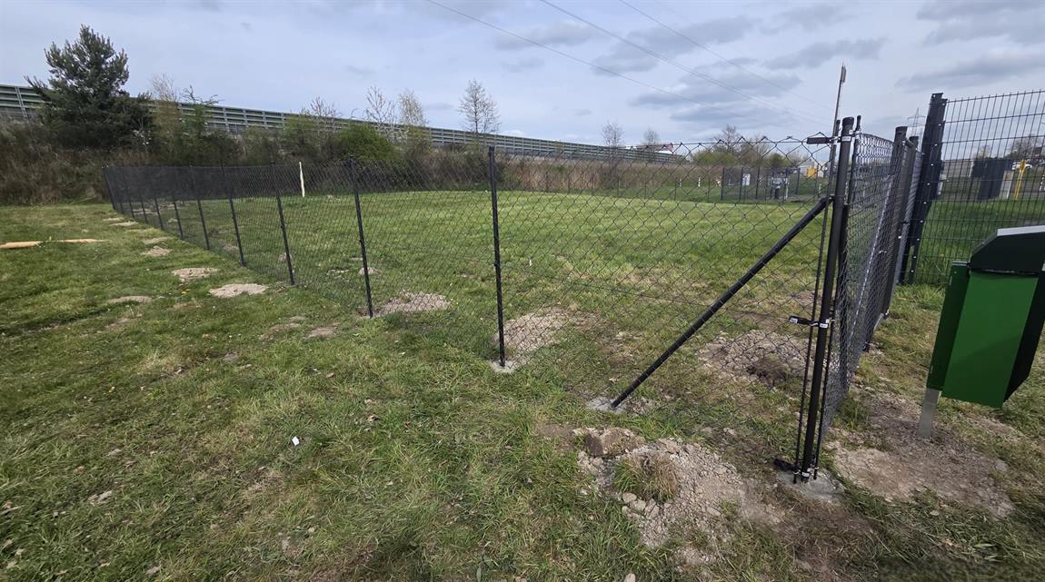 Fertig montierter Maschendrahtzaun mit Spanndraht auf einer Wiese