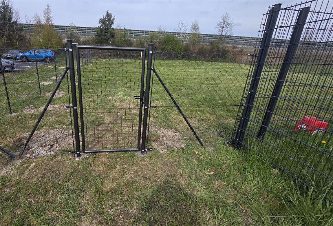 Eingebautes Gartentor aus Metall im neuen Maschendrahtzaun